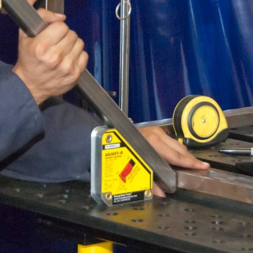Strong Hand Tools MSA48-HD Heavy Duty Adjust-O Magnet Square in use, holding metal in place on a workbench for welding applications.