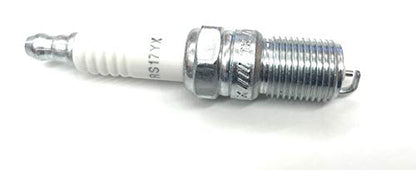 Miller Electric Miller 065709 Spark Plug for Onan P-216/P-218/P-220. This image shows the spark plug with a hexagonal metal base and ceramic insulator, designed for optimal ignition performance in welding machines.